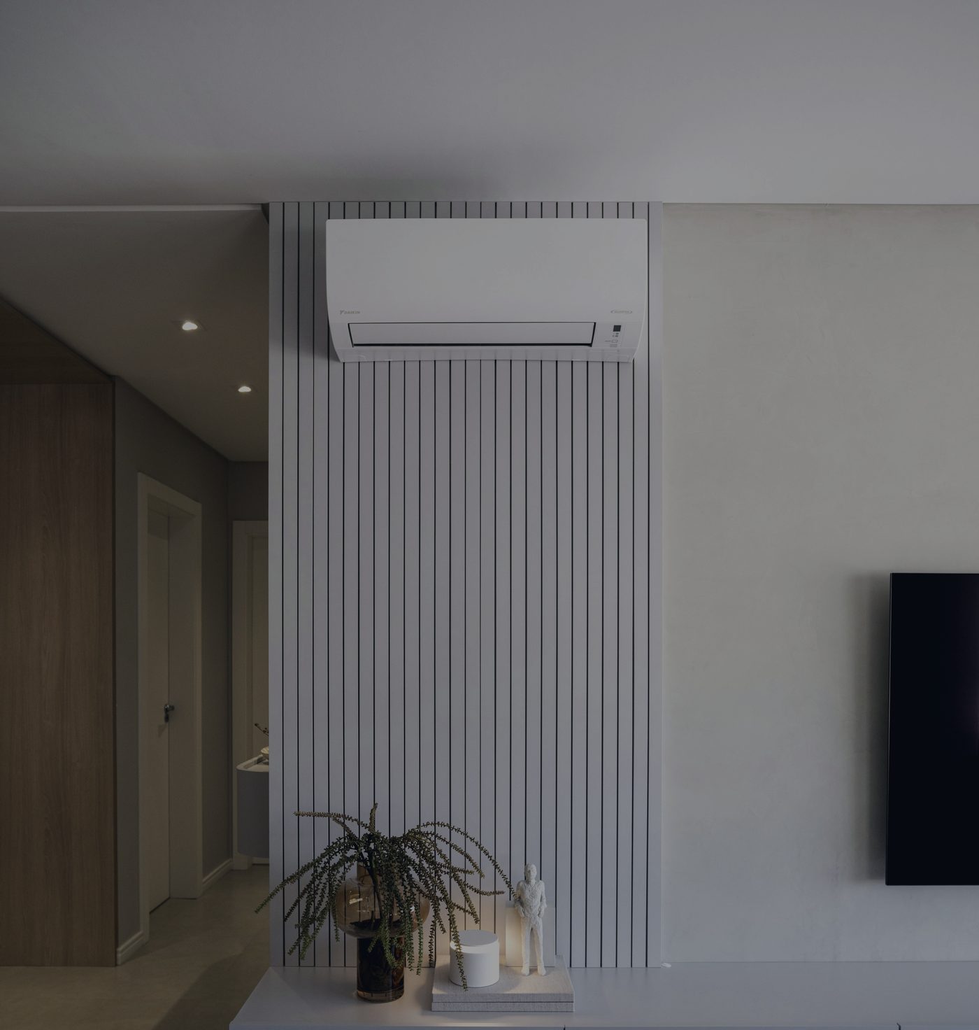 A high-wall heat pump installed above a slatted feature wall in a modern living room