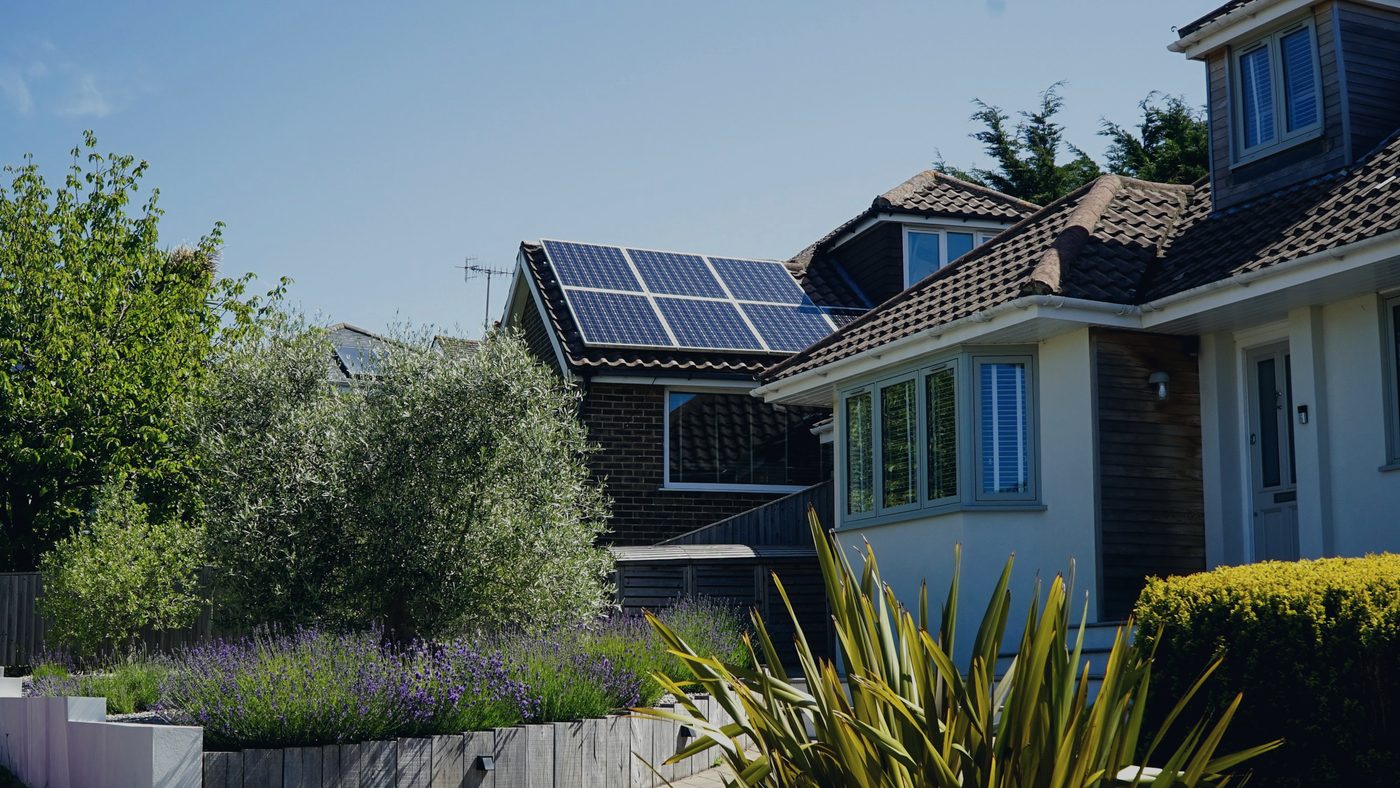 A house with solar panels on its roof under a clear sky